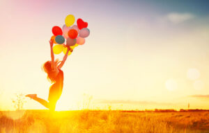 Eine Frau mit einen Strauß Luftballons in der Hand